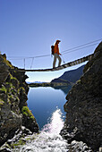 Woman on suspension bridge, lake Wangenitzsee, National Park Hohe Tauern, Carinthia, Austria