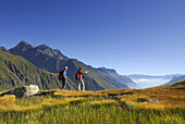 Couple hiking through marsh meadow in autumn, Stubai Alps, Stubai, Tyrol, Austria