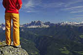 Woman enjoying view to Dolomites with Odle range and Sella range, South Tyrol, Italy