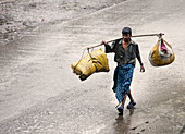 Man walking in the rain, Allahabad. Uttar Pradesh, India