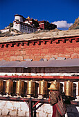 Prayer wheels along outer wall of Potala Palace, Lhasa. Tibet, China