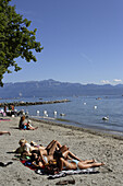 People sunbathing at Lake Geneva, Ouchy, Lausanne, Canton of Vaud, Switzerland