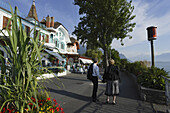 Couple walking along promenade, Montreux, Canton of Vaud, Switzerland
