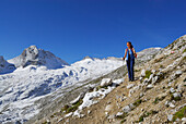 Woman hiking across Zugspitzplatt with view to Plattspitze, Wetterstein range, Upper Bavaria, Bavaria, Germany