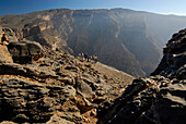 Menschen betrachten die Aussicht in den Al Hajar Bergen, Oman, Asien