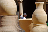 A local man behind big stoneware jugs, Bahla, Oman, Asia