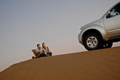 Menschen und Detail eines Geländewagens auf einer Düne, Wahiba Sands, Oman, Asien