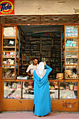 Moroccan woman in front of a shop at Meknes' medina, Meknes, Morocco, Africa