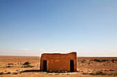 Lonesome, decayed hut at Erg Chebbi desert under blue sky, Morocco, Africa