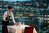 Waitress laying a table at Restaurant Cube with view at the New Castle, Stuttgart, Baden-Wurttemberg, Germany