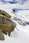 Freerider springt über einen Felsen am Stockhorn, Zermatt, Wallis, Schweiz