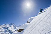 Skifahrer mit Telemark Ski bei der Abfahrt im Tiefschnee, Zinal, Wallis, Schweiz
