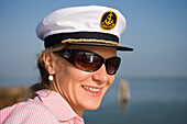 Frau mit Kapitänsmütze an Bord eines Le Boat Magnifique Hausboot, Torcello, Venetien, Italien, Europa