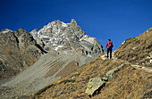 Junge Frau im Aufstieg zur Chamanna d'Es-cha, im Hintergrund der Piz Kesch, Silvretta, Oberengadin, Engadin, Graubünden, Schweiz