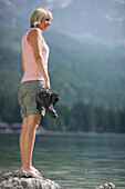 Young woman standing in lake Eibsee, Werdenfelser Land, Bavaria, Germany