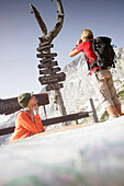 Couple near sign post, Werdenfelser Land, Bavaria, Germany