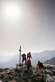 Wanderer erreichen Gipfelkreuz, Wettersteingebirge, Bayern, Deutschland