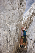 Hikers crossing wind gap, Wetterstein range, Bavaria, Germany