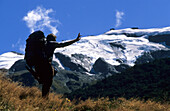 Trekker vor schneebedecktem Berggipfel im Dart Valley auf dem Rees Dart Track, Mt. Aspiring Nationalpark, Südinsel, Neuseeland, Ozeanien