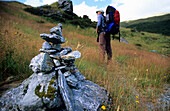 Trekker und Steinmännchen auf dem Rees Dart Track im oberen Dart Valley, Mt. Aspiring Nationalpark, Südinsel, Neuseeland, Ozeanien