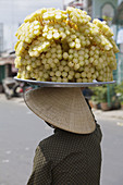 Woman carrying a tray of chunks of sugar cane on sticks, Vinh Long, Mekong Delta, Ha Giang Province, Vietnam