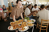 Surf Rider Seafood Restaurant, waitress, food, plates. Hampton. Virginia. USA.