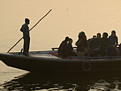 Boats with pilgrims and tourists at dawn in Varanasi, India, a sacred Hindu pilgrimage site.