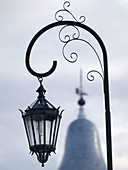Light fixtures in La Recoleta Cemetery in Buenos Aires, Argentina contrast with nearby structures.