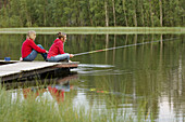 Three persons fishing on a jetty, Vasterbotten, Sweden (July 2005)