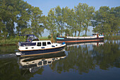 Ein Frachter und ein Hausboot auf dem Fluss Vecht, Holland, Europa