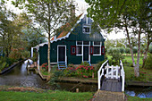 Blick auf ein Haus unter Bäumen an einem Kanal, Freilichtmuseum Zaanseschans, Holland, Europa