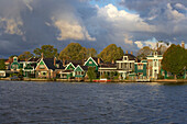 Historische Wohnhäuser am Fluss Zaan unter Wolkenhimmel am Morgen, Zaandijk, Holland, Europa
