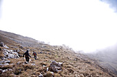 Zwei Menschen wandern durch eine Berglandschaft, Oberstdorf, Bayern, Deutschland