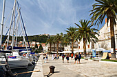 Menschen bummeln auf der Promenade im Jachthafen von Hvar, Insel Hvar, Dalmatien, Kroatien, Europa