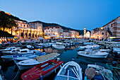 Boats at harbour and palace hotel at the Old Town in the evening, Hvar, Hvar Island, Dalmatia, Croatia, Europe