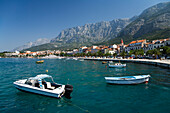 Boote im Wasser und Häuser von Makarska vor Berglandschaft, Dalmatien, Kroatien, Europa