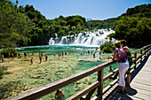 Menschen baden im Fluss an den Krka Wasserfällen, Krka Nationalpark, Dalmatien, Kroatien, Europa