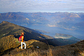 Frau genießt die Aussicht auf den Comer See, Monte Legnone, Bergamasker Alpen, Como, Lombardei, Italien