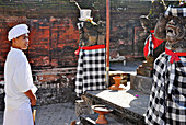 Rambut Siwi, local standing in front of temple figures, West Bali, Indonesien, Asia