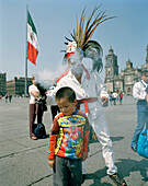 A man wearing an aztec costume and people at the square in front of the cathedral, Zocalo, Mexico City, Mexico, America