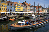 Tourist boat and typical architecture at Nyhavn canal. Copenhagen. Denmark