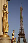 Gilded bronze statue decorating the central square of the Palais de Chaillot with Eiffel Tower in the background. Paris. France
