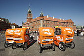 Tricycle taxis waiting for customers in Castle Square with Royal Castle in the background. Warsaw Old Town. Warsaw. Poland