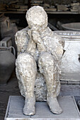 Plaster cast of a human boy in ancient ruins city of Pompei. Campania. Italy