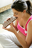 Pregnant woman eating bar of chocolate
