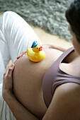Pregnant woman with rubber duck on belly