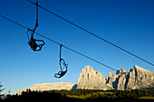 Chair lift in front of mountain scenery and blue sky, Val Gardena, Valle Isarco, South Tyrol, Italy, Europe