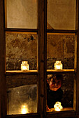 A boy looking through a candle-lit window at the christmas market, Glurns, Val Venosta, South Tyrol, Italy, Europe