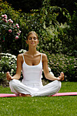 Woman sitting cross-legged, doing yoga exerceses, Meditation, Relaxation, Wellness, Holiday, South Tyrol, Italy
