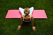 Frau sitzt im Schneidersitz, macht Yoga Übungen, Meditation, Entspannung, Wellness, Urlaub, Südtirol, Italien